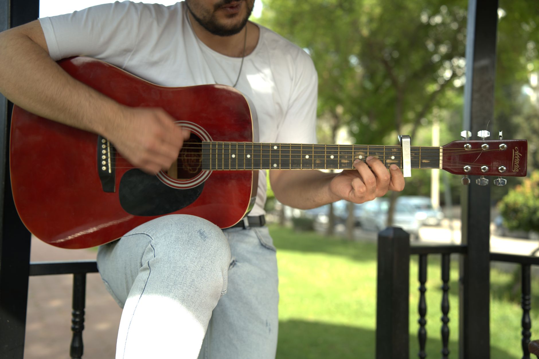 נגן גיטרה אקוסטית עם קאפו על הגריף באור יום — נגינת השיר עד מחר של אביתר בנאי